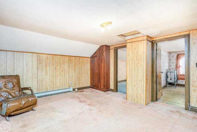 additional living space with baseboard heating, wood walls, light colored carpet, and vaulted ceiling