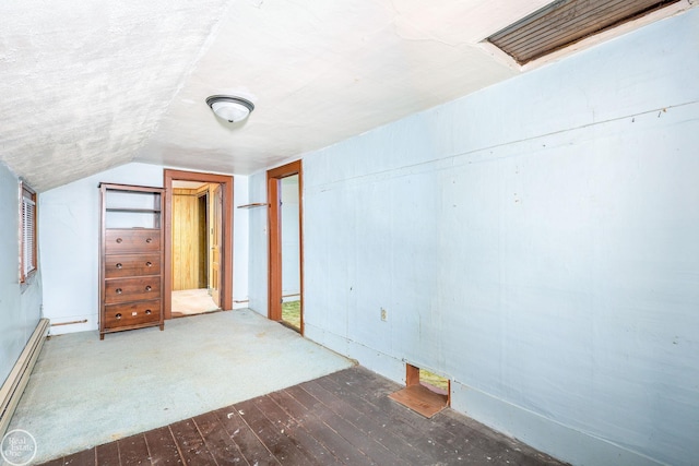 additional living space featuring dark hardwood / wood-style floors, baseboard heating, and lofted ceiling