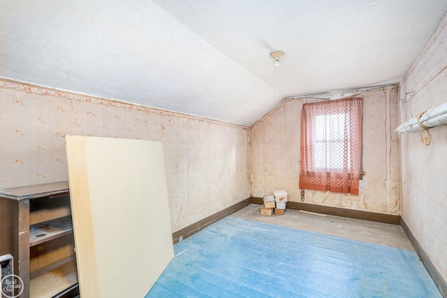 additional living space with wood-type flooring and vaulted ceiling