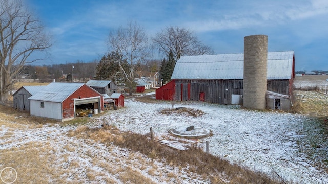 snowy yard featuring an outbuilding