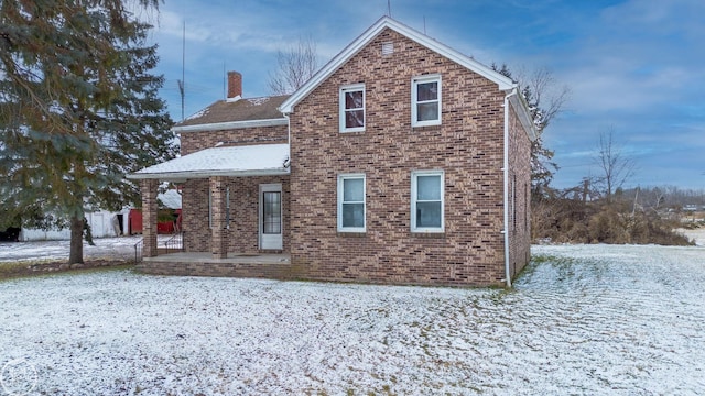 view of snow covered rear of property