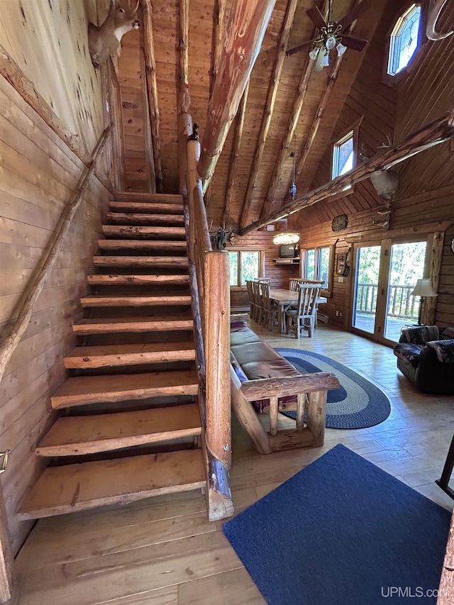 stairs featuring hardwood / wood-style flooring, high vaulted ceiling, plenty of natural light, and wooden ceiling