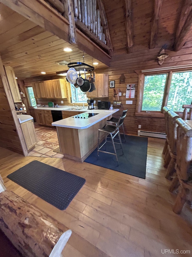 kitchen with a kitchen bar, a center island, light hardwood / wood-style floors, and wood ceiling