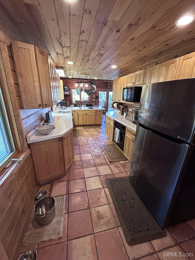 kitchen with sink, light brown cabinets, wooden ceiling, wood walls, and black appliances