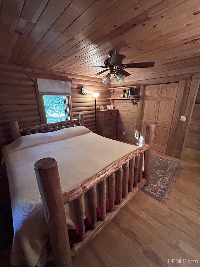 bedroom featuring wood ceiling, rustic walls, ceiling fan, and wood-type flooring