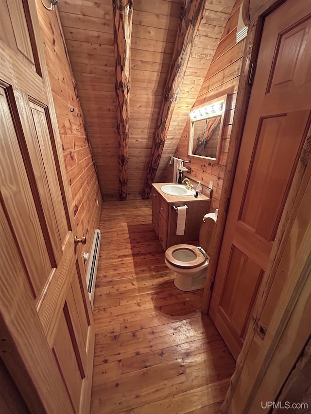 bathroom featuring a baseboard radiator, wooden ceiling, hardwood / wood-style floors, lofted ceiling, and wood walls