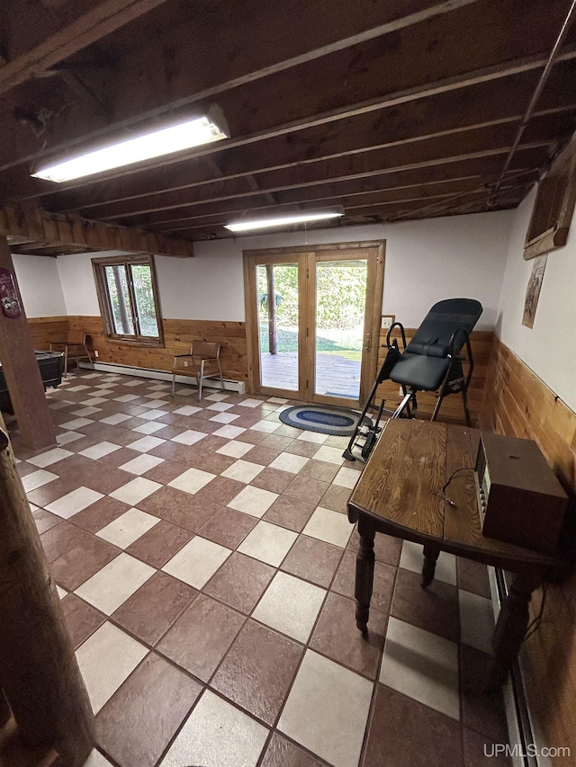 miscellaneous room with wooden walls, a healthy amount of sunlight, and a baseboard heating unit