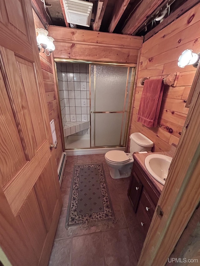 bathroom featuring a baseboard heating unit, toilet, wooden walls, vanity, and a shower with shower door