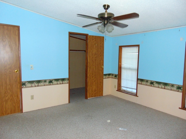 unfurnished bedroom featuring carpet, a textured ceiling, ceiling fan, and lofted ceiling