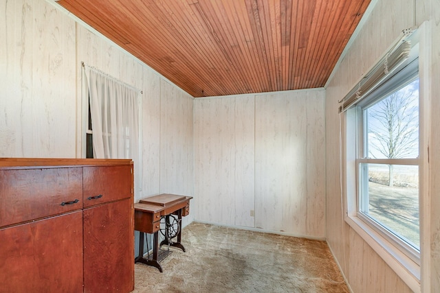 interior space with wood ceiling, wooden walls, and light colored carpet