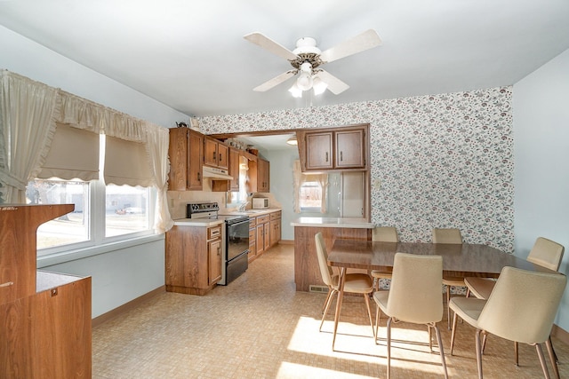 kitchen with kitchen peninsula, black range with electric cooktop, and ceiling fan