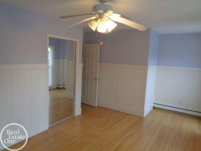 bonus room with ceiling fan, wood-type flooring, and a baseboard heating unit