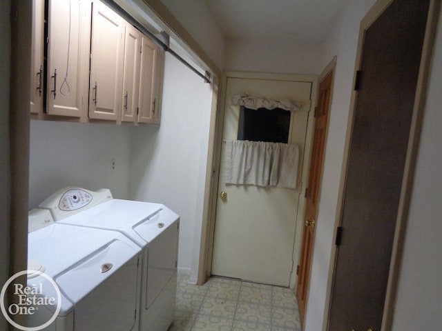 clothes washing area featuring washing machine and dryer and cabinets