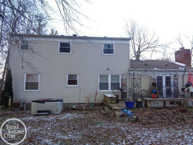 back of house featuring a hot tub