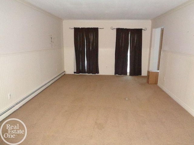 carpeted empty room featuring ornamental molding and a baseboard heating unit