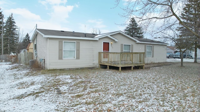 snow covered rear of property featuring a deck