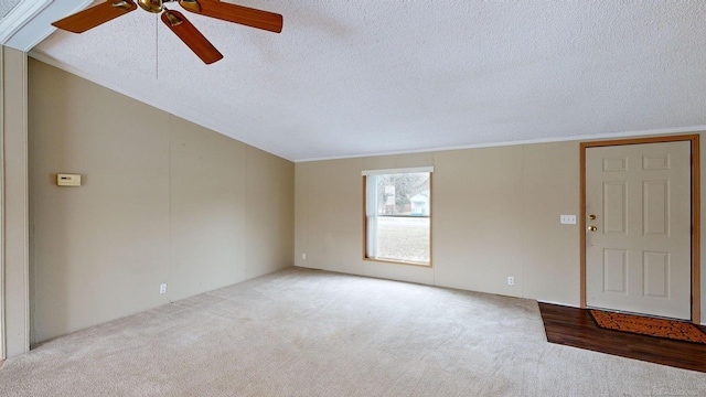 unfurnished living room with light carpet, a textured ceiling, and ceiling fan