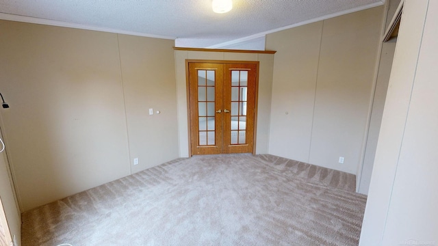 spare room featuring carpet flooring, crown molding, a textured ceiling, and french doors