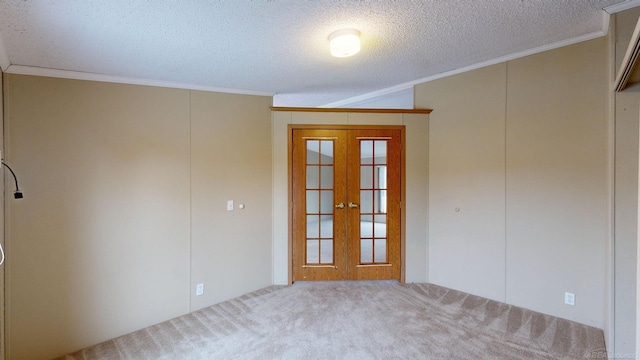 empty room with carpet, french doors, a textured ceiling, and ornamental molding