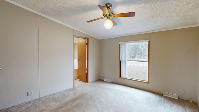 empty room with ornamental molding, a textured ceiling, light colored carpet, vaulted ceiling, and ceiling fan