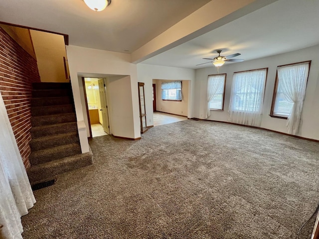 unfurnished living room with ceiling fan and carpet