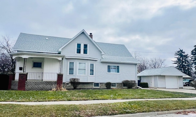 view of front of house featuring a porch, a garage, an outbuilding, and a front yard