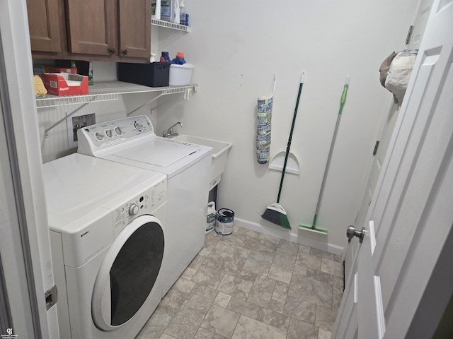 clothes washing area with cabinets and washer and clothes dryer