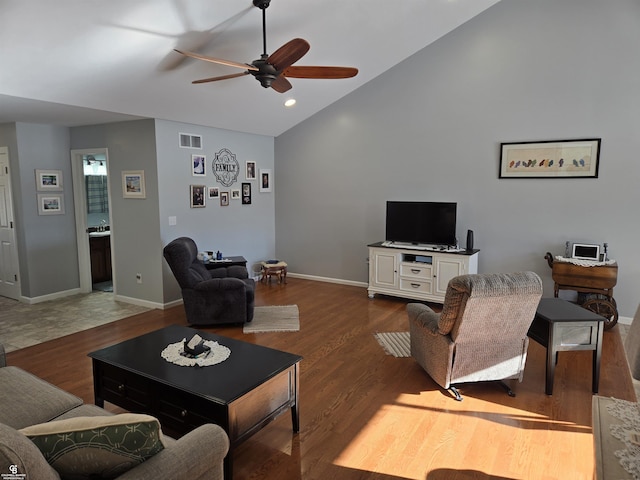 living room with ceiling fan, dark hardwood / wood-style flooring, and vaulted ceiling