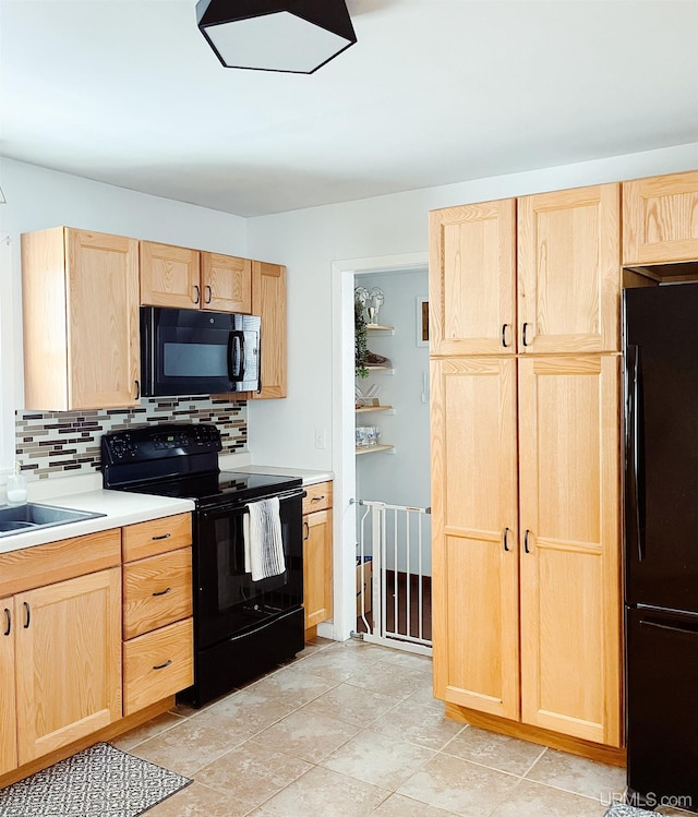 kitchen with light brown cabinets, sink, tasteful backsplash, and black appliances