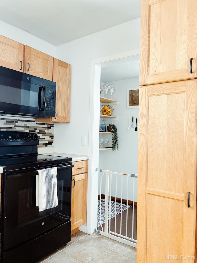 kitchen featuring black appliances, light brown cabinetry, and tasteful backsplash