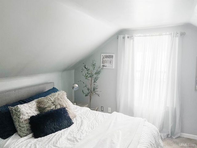 carpeted bedroom with lofted ceiling