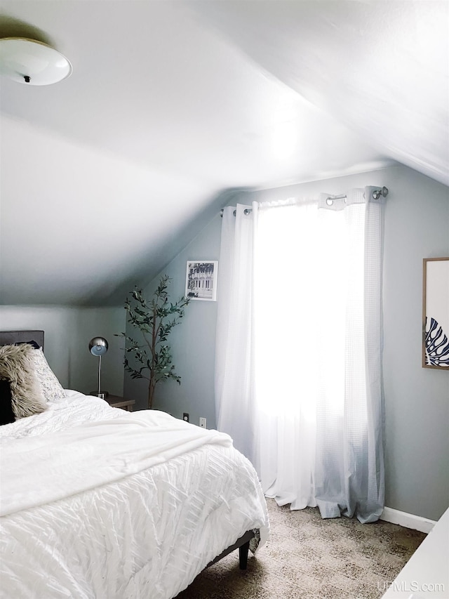 bedroom with carpet floors and vaulted ceiling