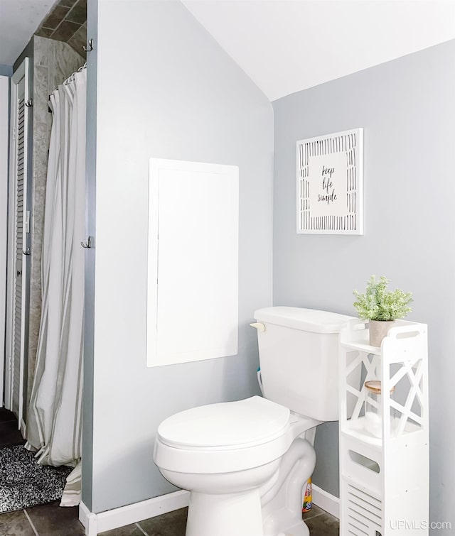 bathroom featuring a shower with curtain, toilet, and lofted ceiling