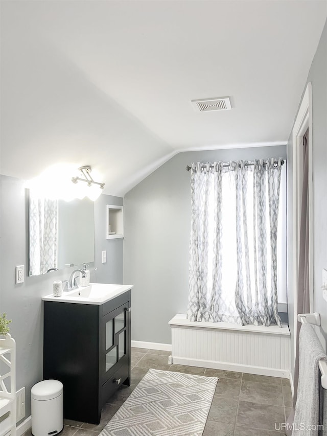 bathroom with vanity and lofted ceiling