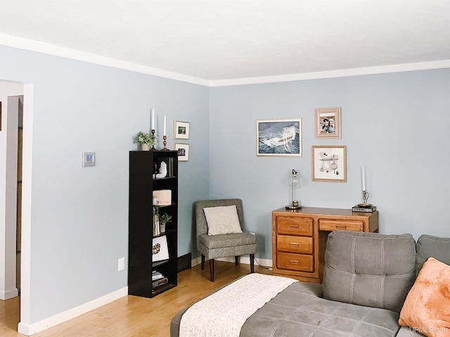 living area featuring light wood-type flooring and ornamental molding