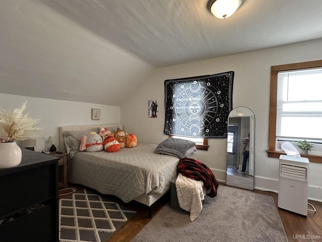 bedroom featuring dark wood-type flooring and vaulted ceiling