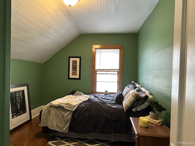 bedroom featuring dark hardwood / wood-style flooring and lofted ceiling