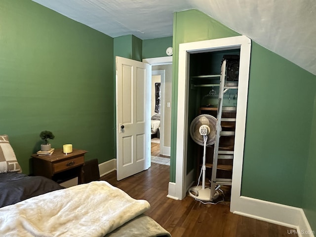 bedroom featuring lofted ceiling, a closet, and dark wood-type flooring