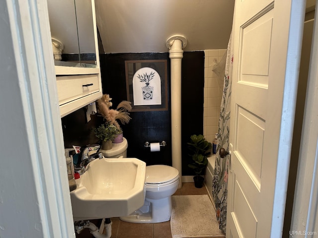 bathroom featuring toilet, sink, and tile patterned flooring