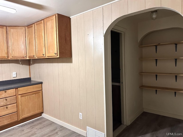 kitchen with light hardwood / wood-style floors and wooden walls