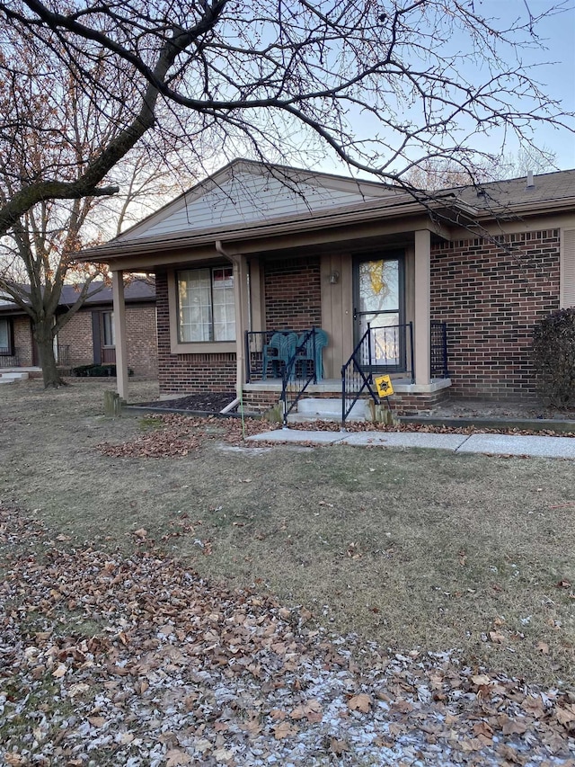 single story home featuring a porch and a front yard