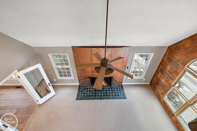 details featuring carpet flooring, wooden walls, and a tiled fireplace