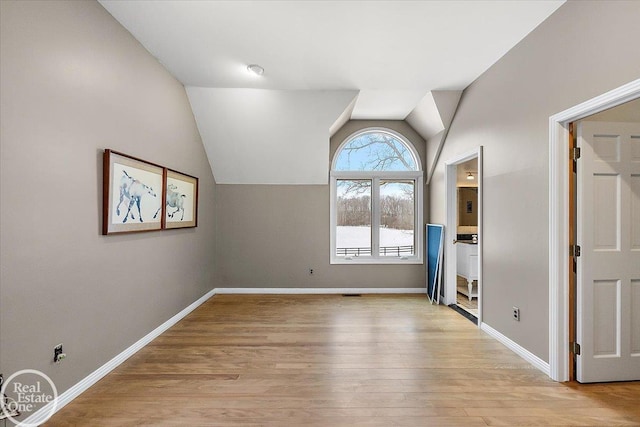 interior space featuring light wood-type flooring and vaulted ceiling