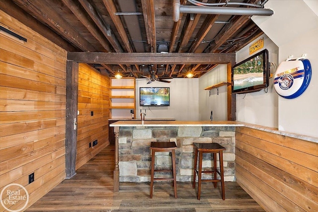 bar featuring ceiling fan, wood walls, and dark hardwood / wood-style floors