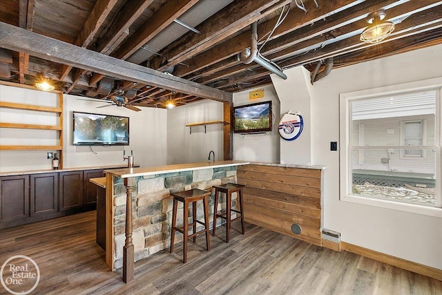 bar featuring hardwood / wood-style flooring and ceiling fan