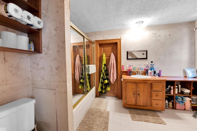 full bathroom with vanity, a textured ceiling, enclosed tub / shower combo, and toilet