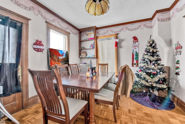 dining area featuring a textured ceiling, ornamental molding, and light parquet flooring