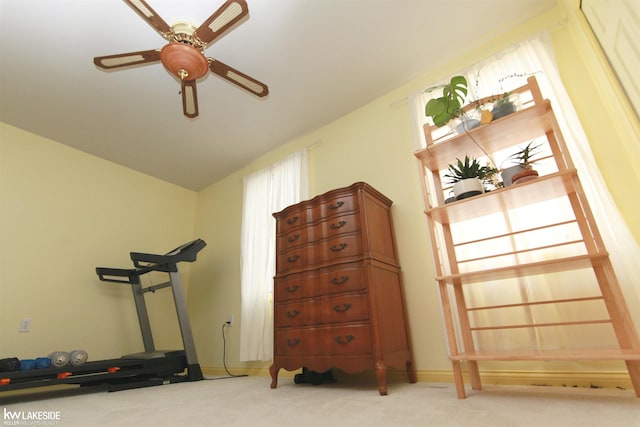 exercise room with carpet, vaulted ceiling, and ceiling fan