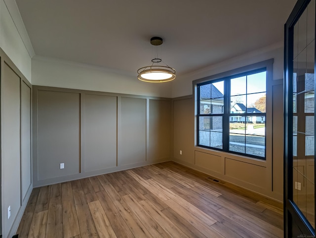 unfurnished bedroom featuring ornamental molding and light wood-type flooring