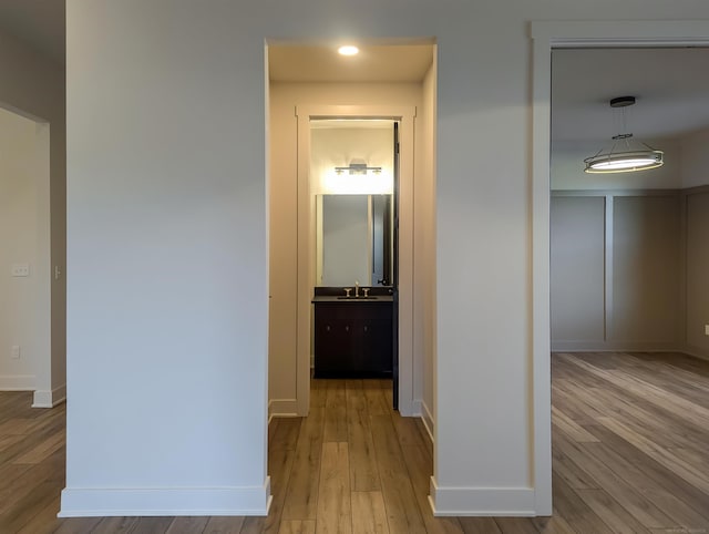 corridor featuring light hardwood / wood-style flooring and sink